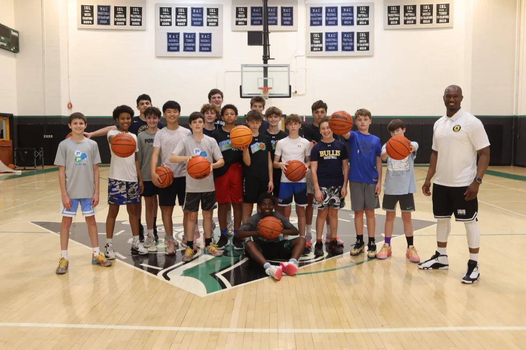 With a youth team in front of championship banners