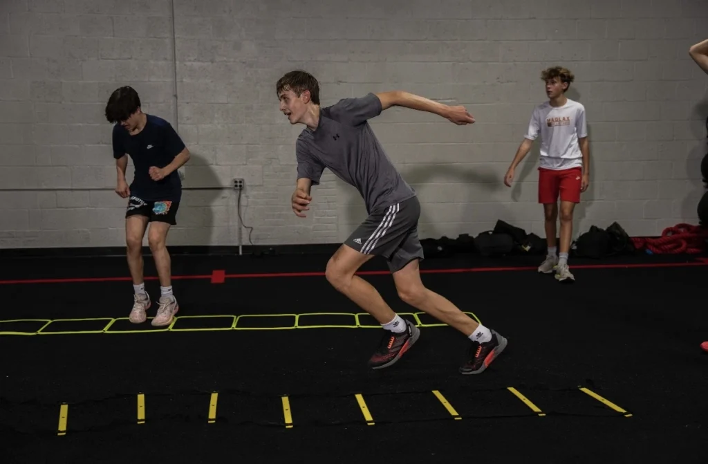 Athlete performing an agility ladder sprint during Performance/SAQ training