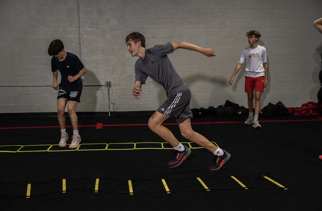 Athlete performing an agility ladder sprint during Performance/SAQ training