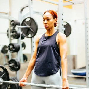 Adult client performing a strength training exercise with Coach Emmanuel